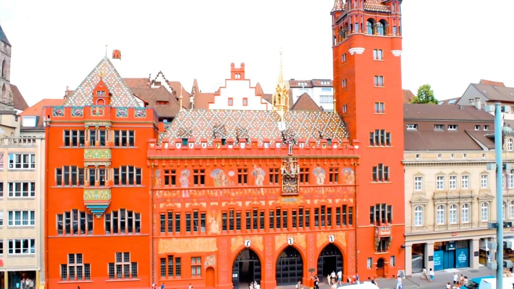 The City Hall in Basel, Switzerland is a large red building with mosaics. A must-see for what to do in Basel