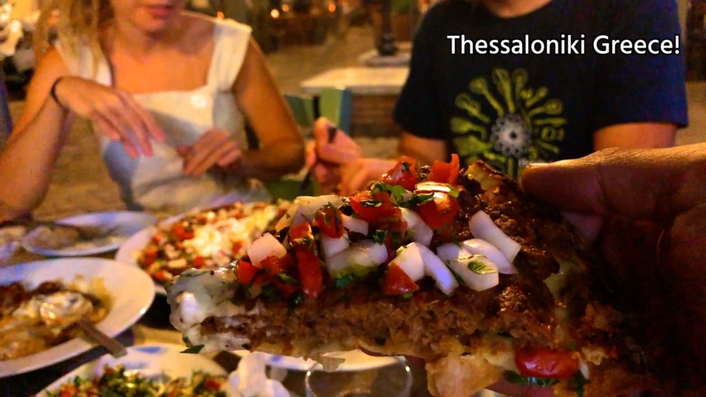 Don't miss the giaourtlou in Thessaloniki! A seasoned meat patty with tomatoes and onions on top of a thin dough crust