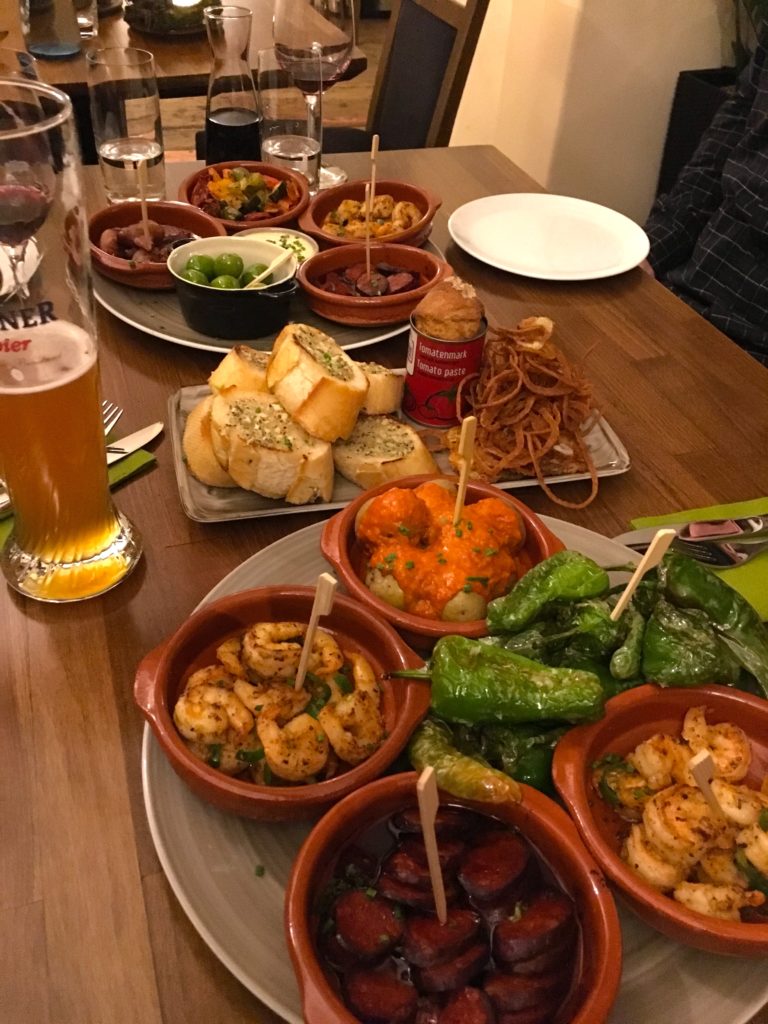 Die Kleine Rosteria appetizers including gambas, garlic bread, and sausages