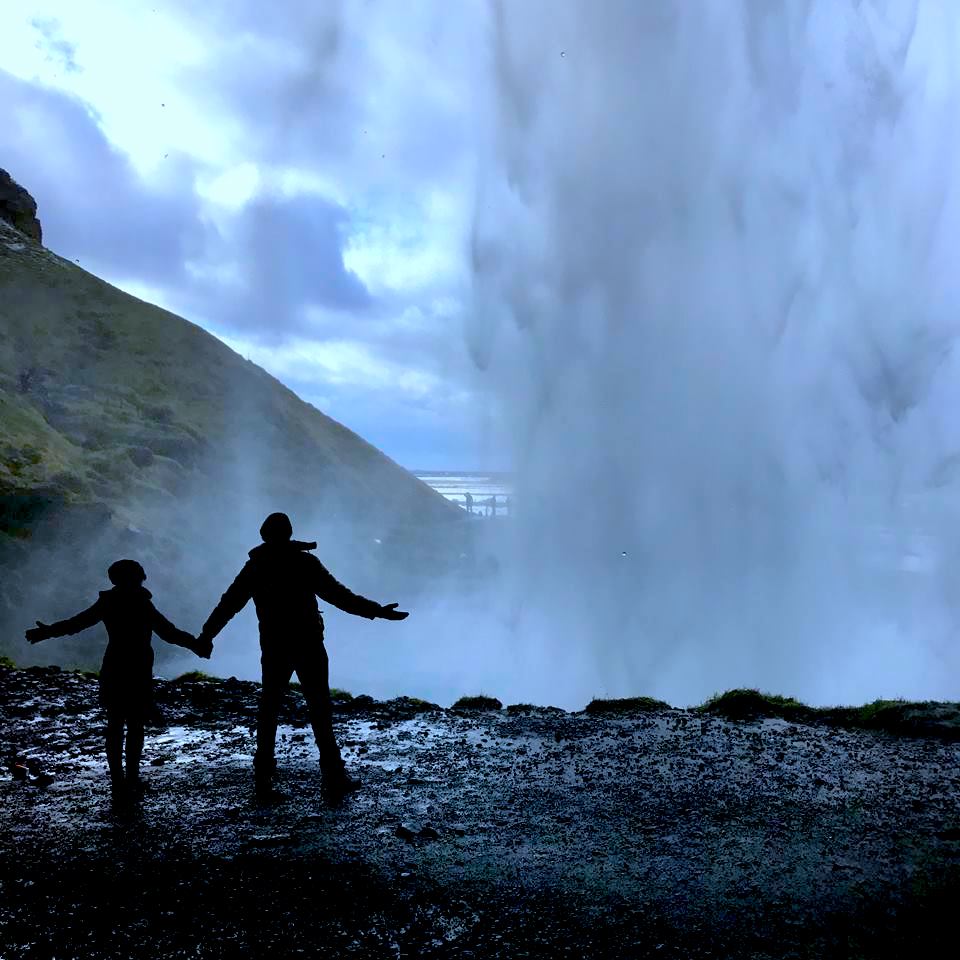 Standing behind the Seljalandsfoss waterfall in Iceland